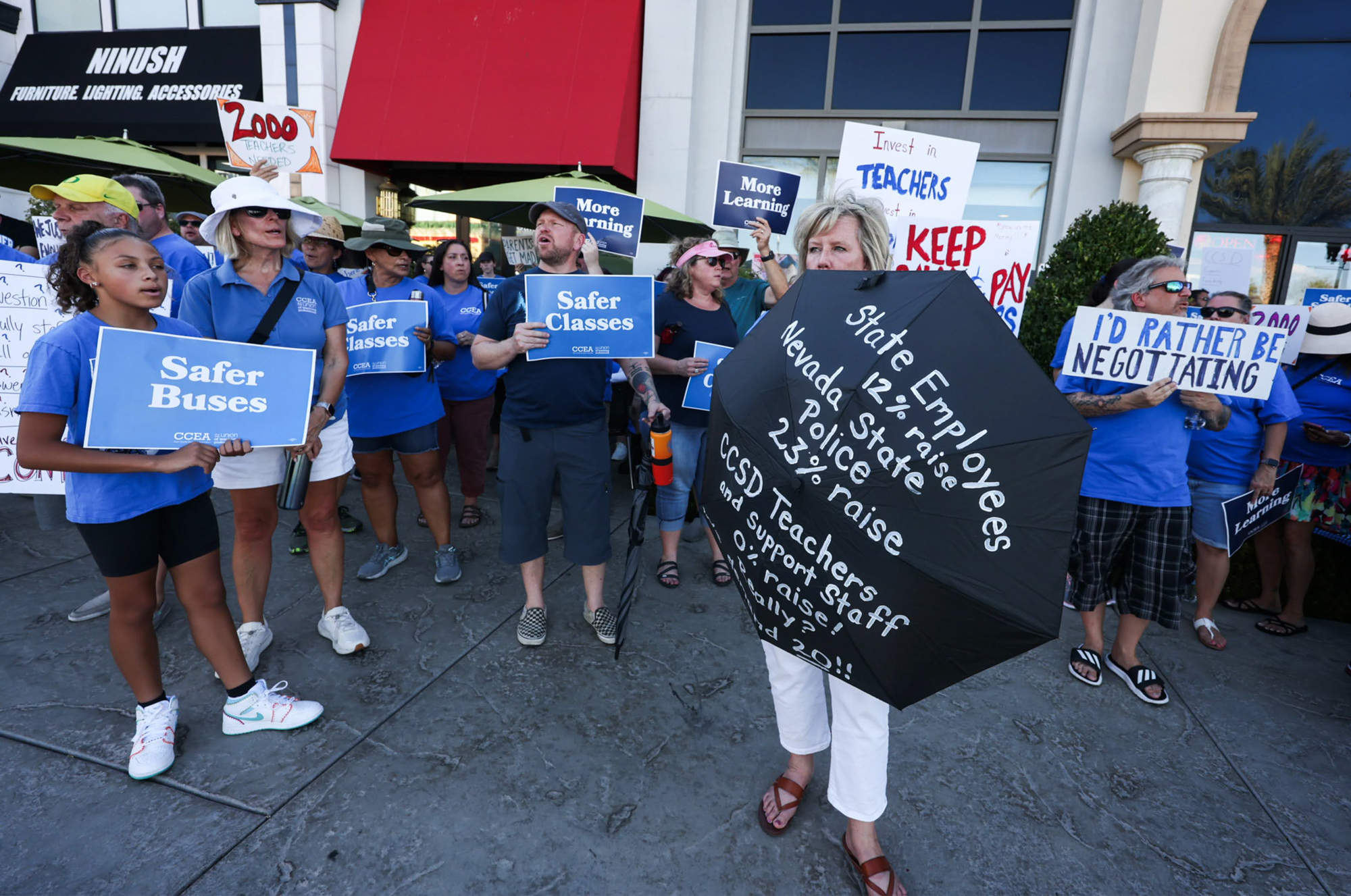 Members of Clark County Education Association protest in front of Sambalatte coffee shop while Clark County School District Superintendent Jesus Jara meets with parents during Java with Jara event on Tuesday, July 18, 2023. (Jeff Scheid/The Nevada Independent)